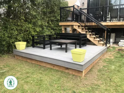 Small grey deck on ground.