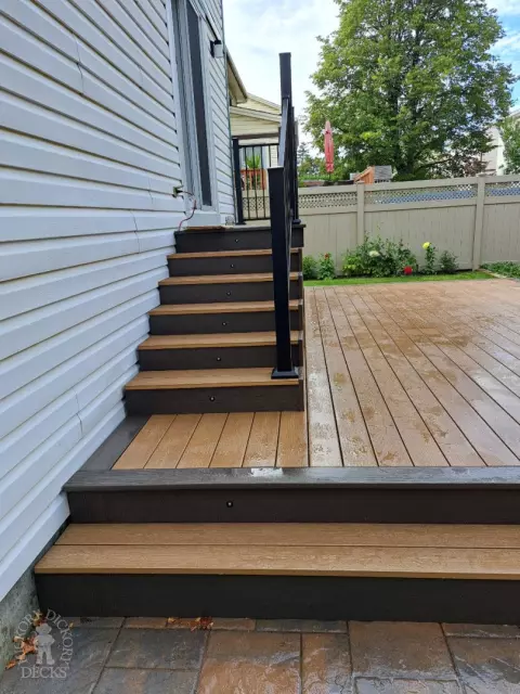 Multi level brown deck with glass railing, and a dark brown border.