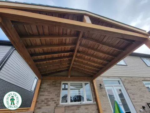 Large grey clubhouse deck with black aluminum railing and a custom cedar roof structure