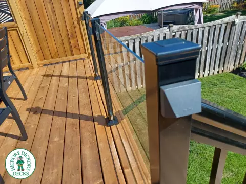 Mid rise pressure treated deck with glass railings, steps, and a custom cedar privacy screen