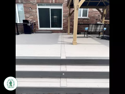 3 steps leading to a large Azek deck with lighting in the steps, and black aluminum railings.