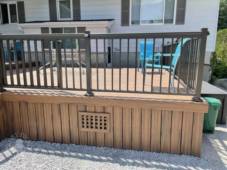 Small brown composite deck with steps and black aluminum railing.