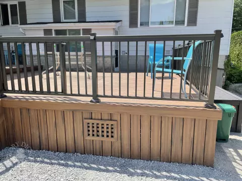 Small brown composite deck with steps and black aluminum railing.