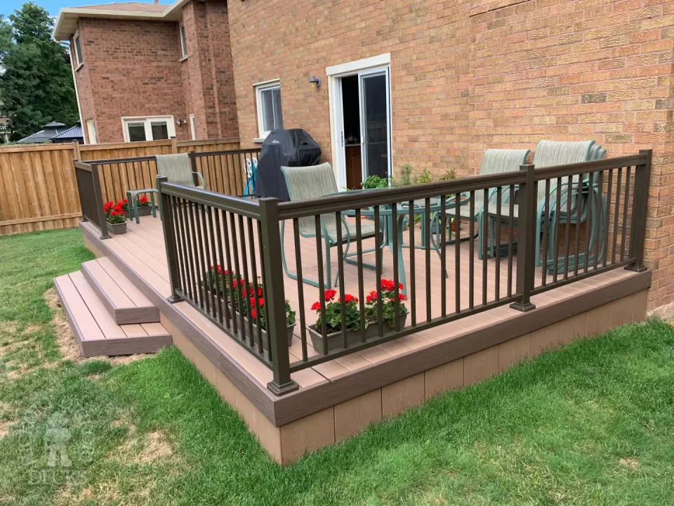 Small brown veka deck with two steps and aluminum railing.