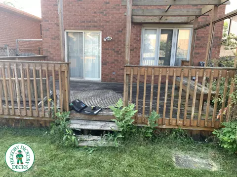 Small brown composite deck with three steps leading to yard.