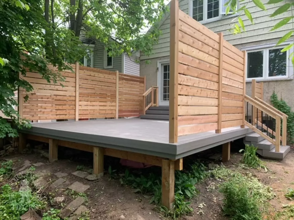 Grey fiberon deck with cedar railing and a cedar privacy screen.