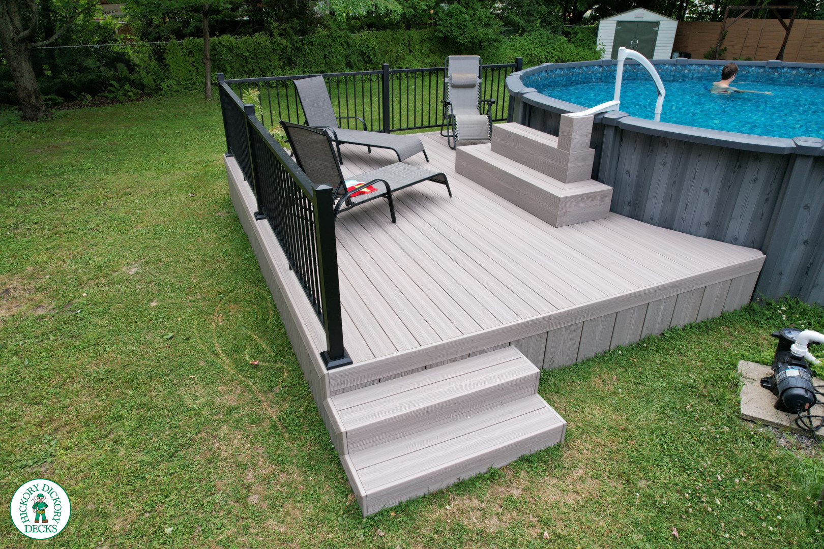 Small grey fiberon deck built around an above ground pool.