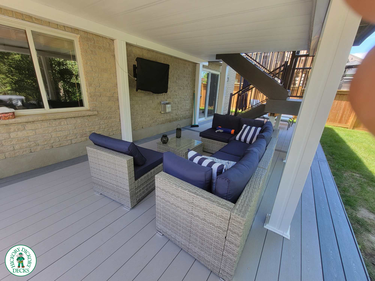 Multi level grey clubhouse deck with dark grey border and glass privacy screens on the top level.