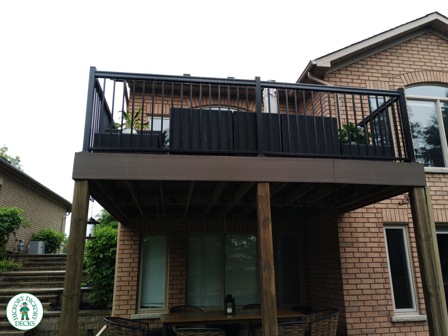 High brown azek deck with black railing.