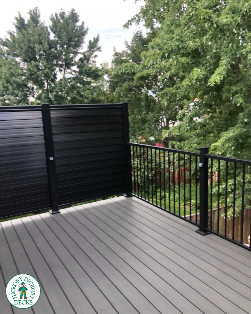 High clubhouse deck in dark grey with black aluminum railing and black privacy screen.
