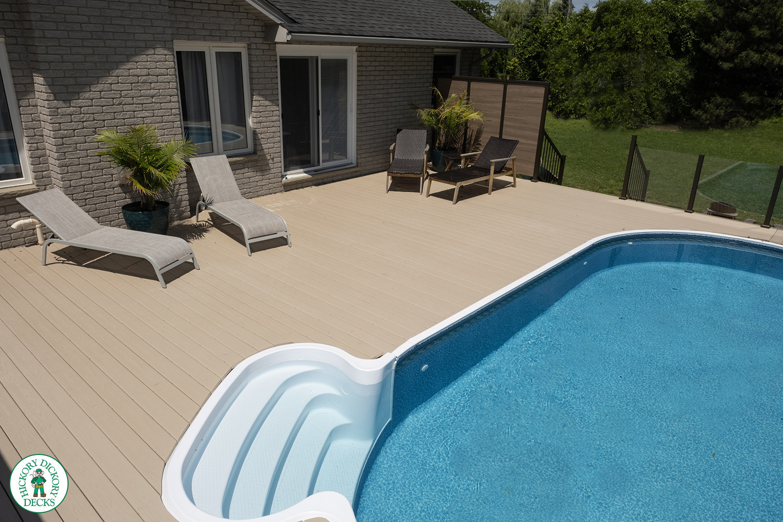 Large brown deck surrounding an above ground pool