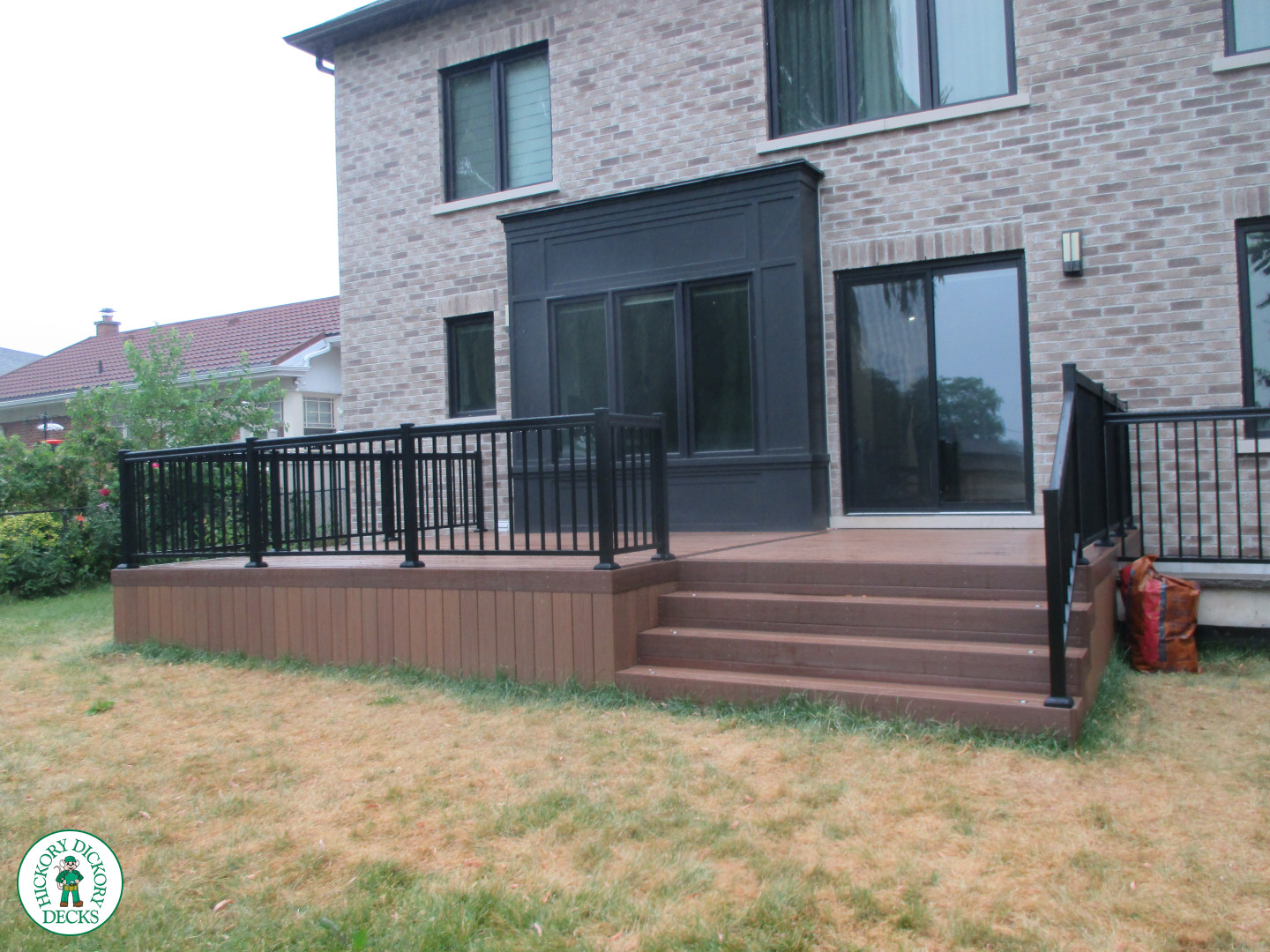 Low brown composite deck with black aluminum railing