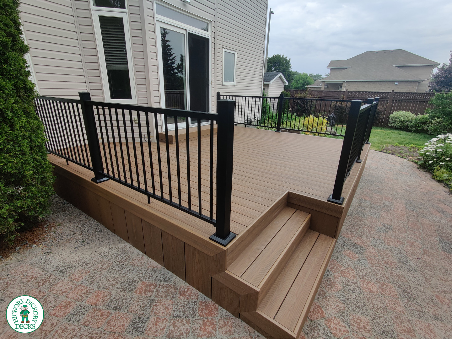 192 square foot fiberon in brown with three steps up to deck and black aluminum railing.