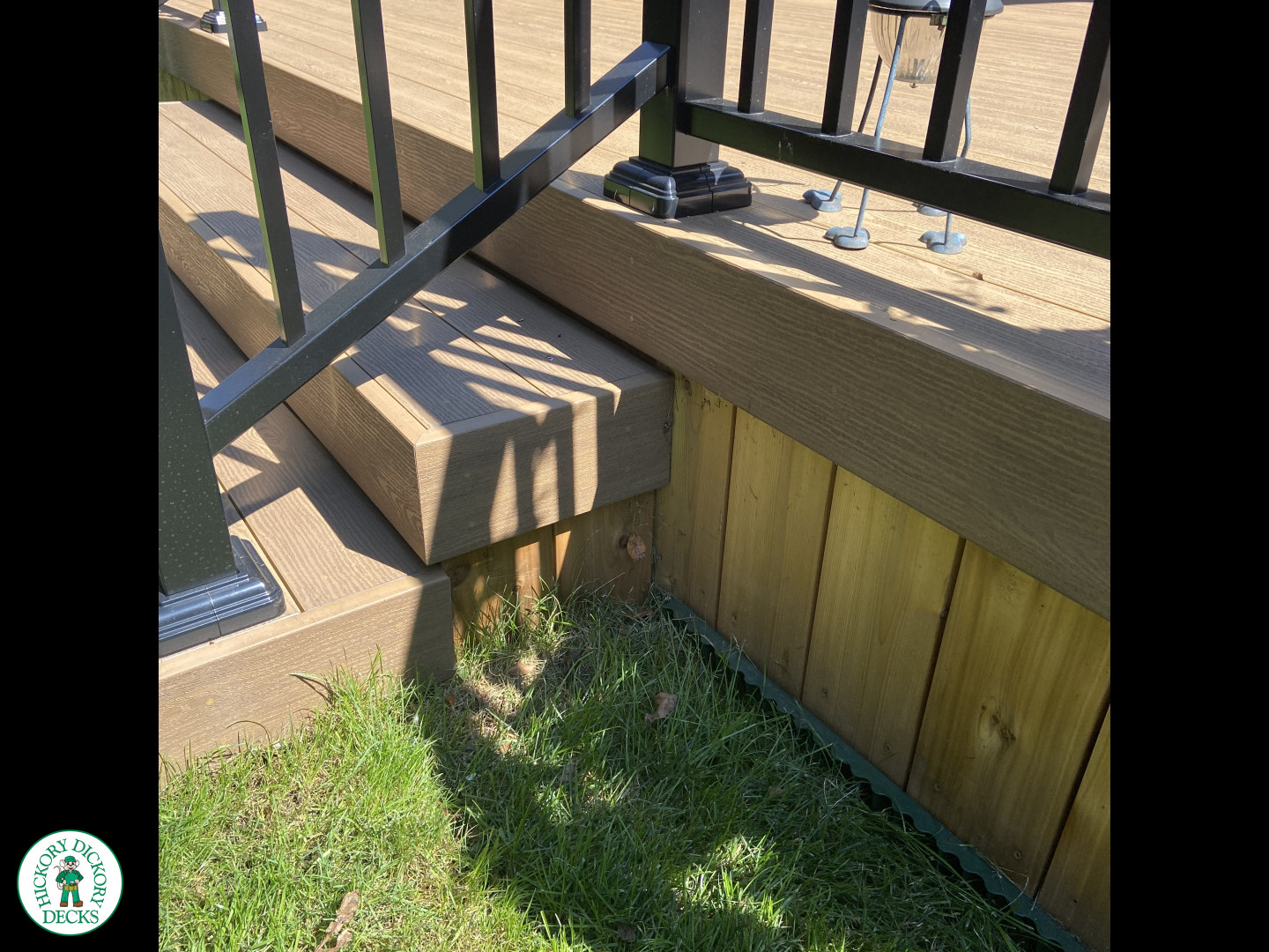 3 steps leading to small brown clubhouse deck with black aluminum railing.