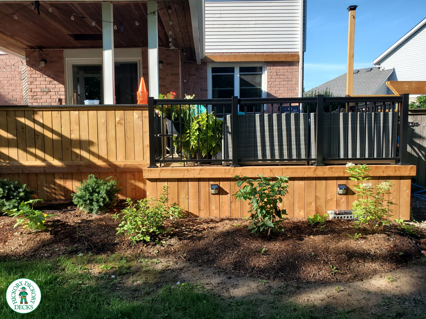 Cedar deck with roof structure that has a built in bar, and aluminum railings with a gate insert.