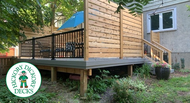 Grey fiberon deck with cedar railing and a cedar privacy screen.