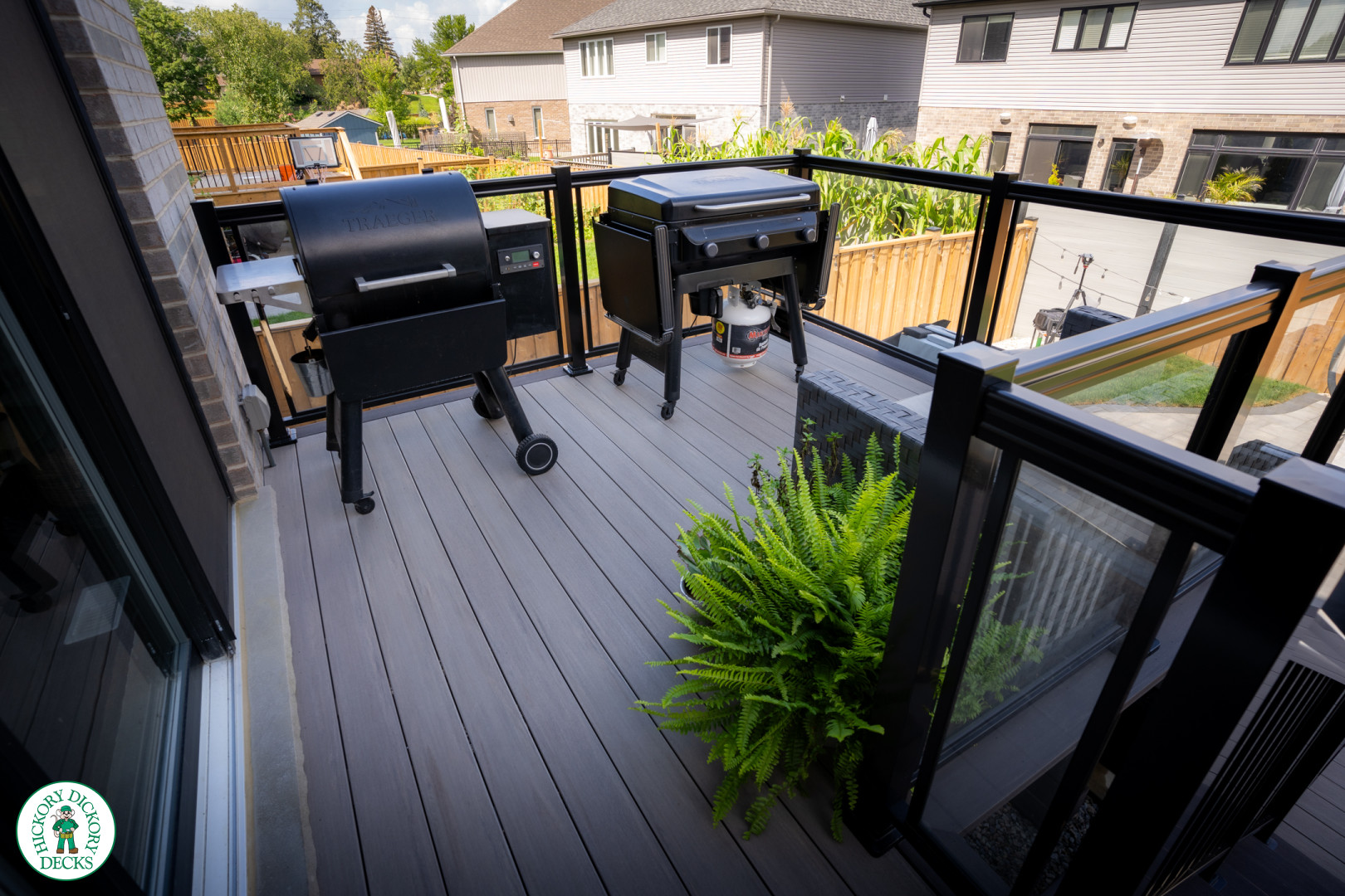 2 level brown composite deck with unique stairs and black aluminum railing. in Waterloo