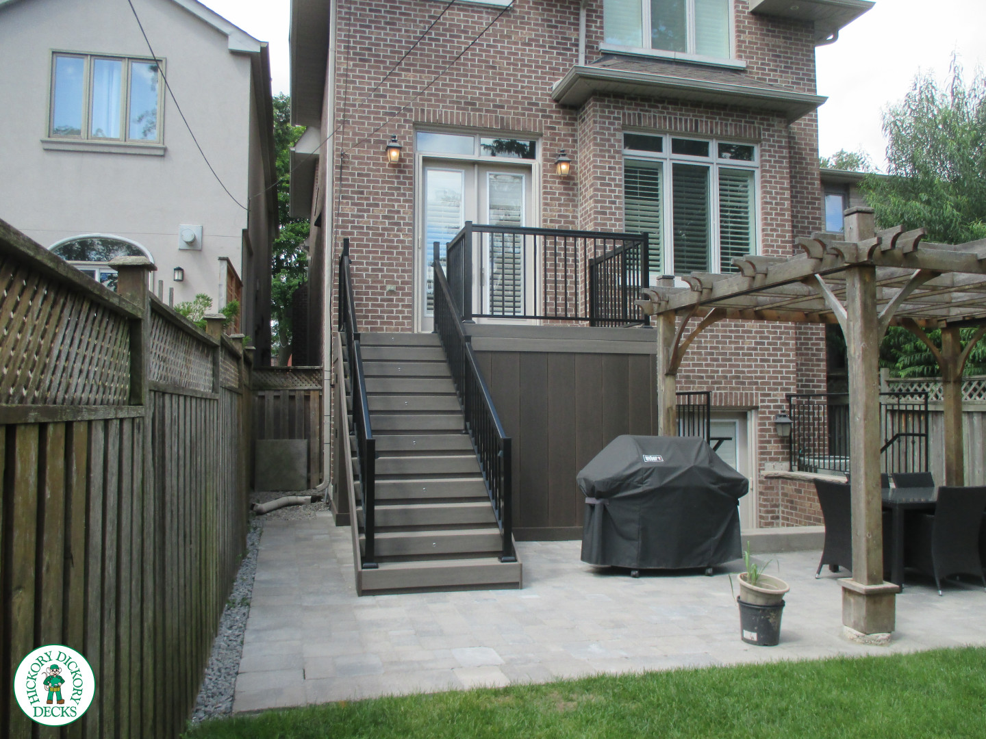 Elevated grey clubhouse deck with black aluminum railing and lights in steps.