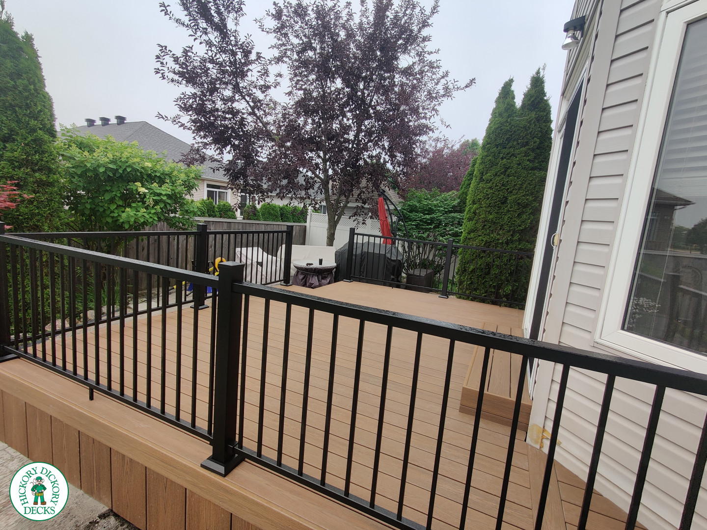 192 square foot fiberon in brown with three steps up to deck and black aluminum railing.