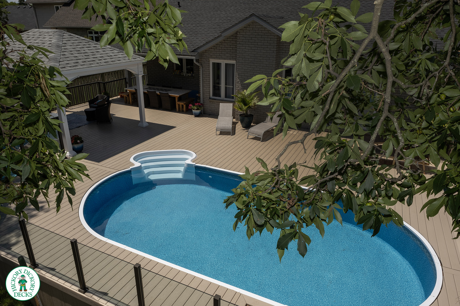 Large brown deck surrounding an above ground pool