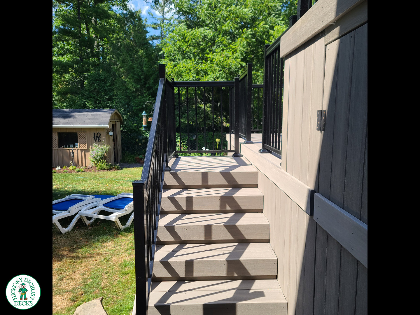 2 level grey composite deck with black aluminum railing.