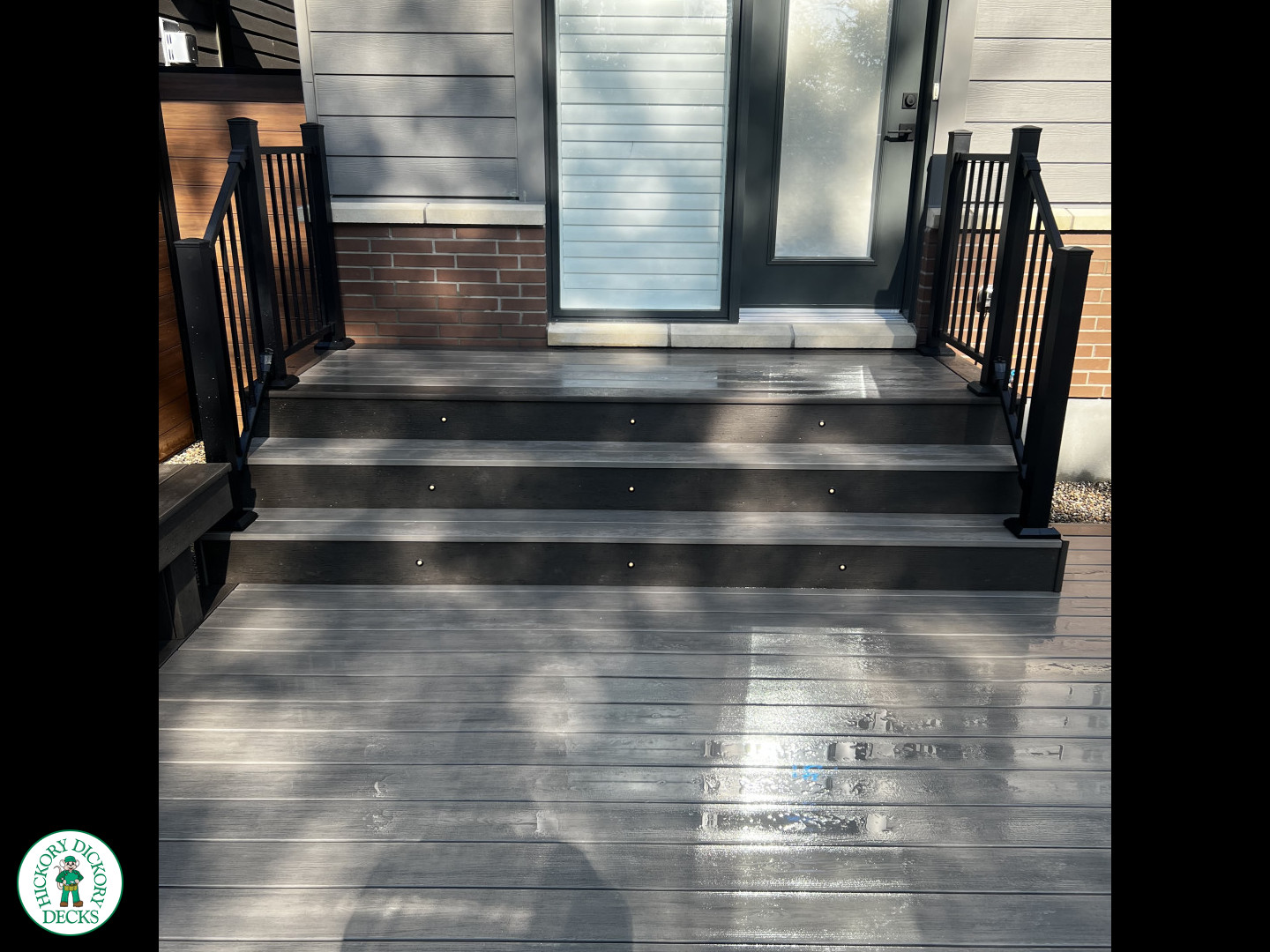 Grey Clubhouse deck with dark grey border, lighting in steps, and a custom bench.