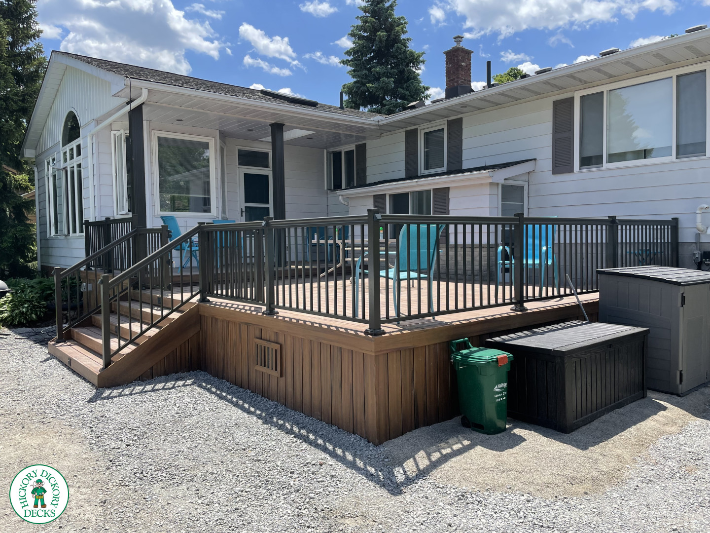 Small brown composite deck with steps and black aluminum railing.