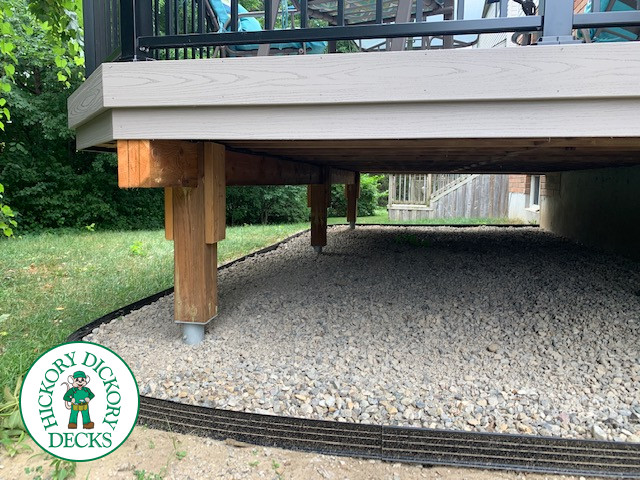 Mid size elevated deck built in grey composite with black railing.