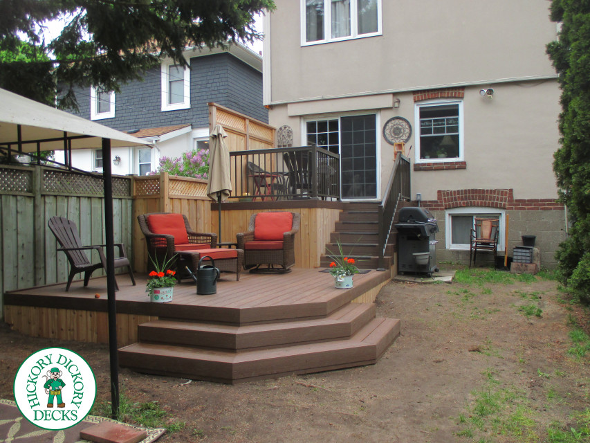 2 level brown composite deck with unique stairs and black aluminum railing.