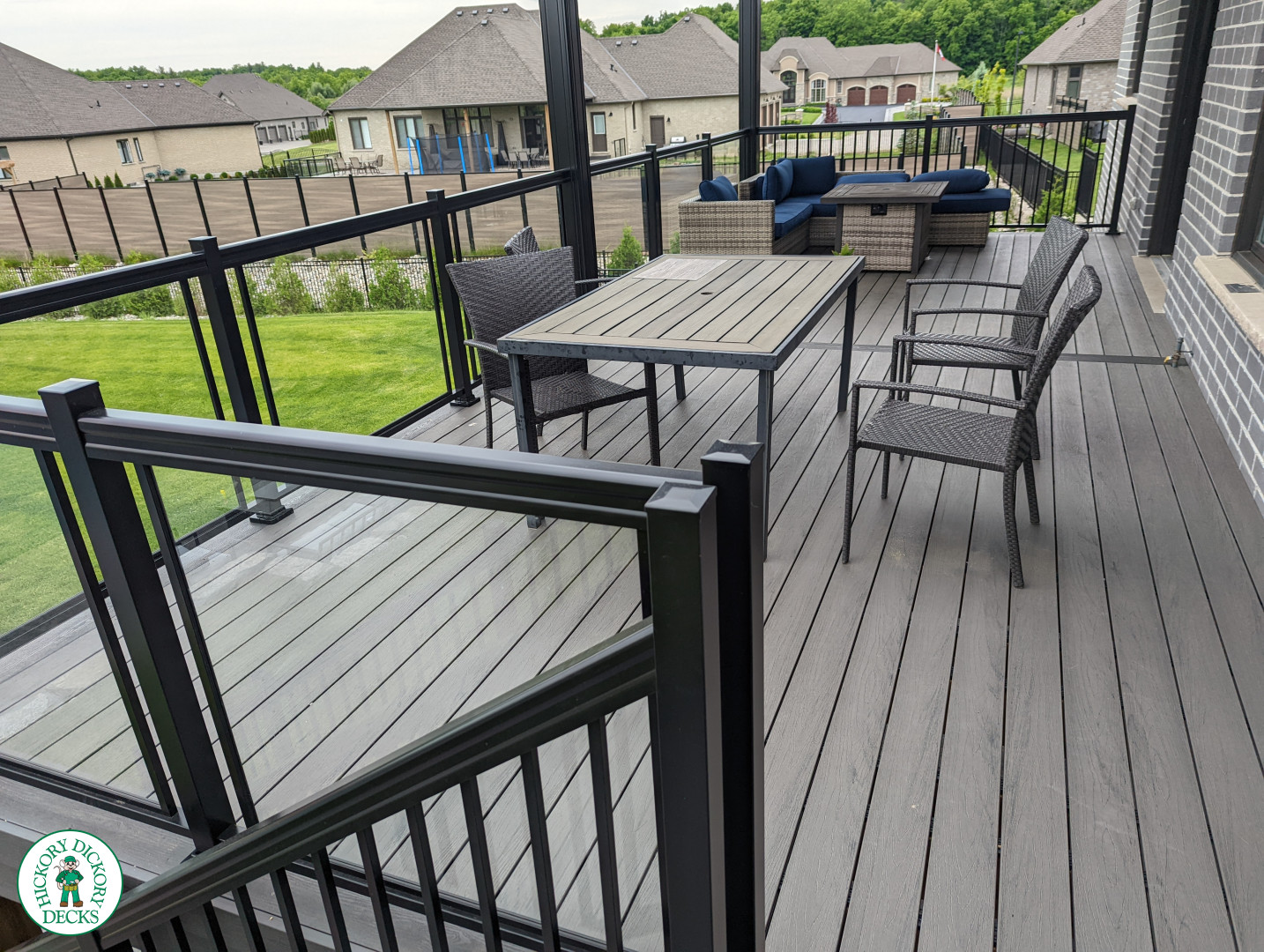 Large high grey trunorth deck with glass railings, and a custom roof structure.