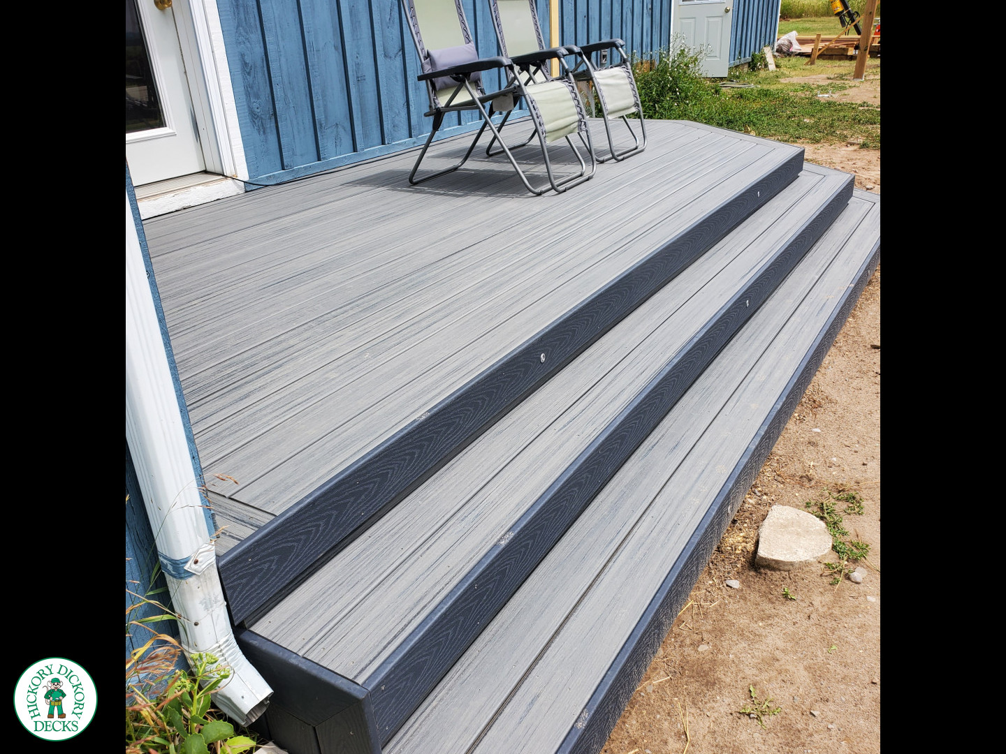 Small grey composite deck with angles steps leading to backyard