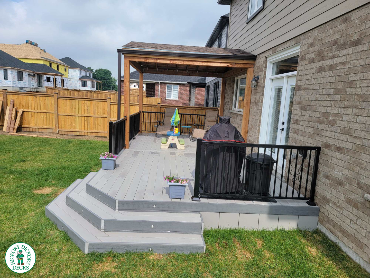 Large grey clubhouse deck with black aluminum railing and a custom cedar roof structure