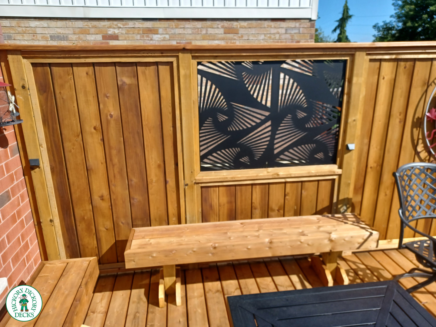 Mid rise pressure treated deck with glass railings, steps, and a custom cedar privacy screen
