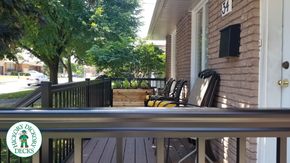 Small brown fiberon porch with black aluminum railing.