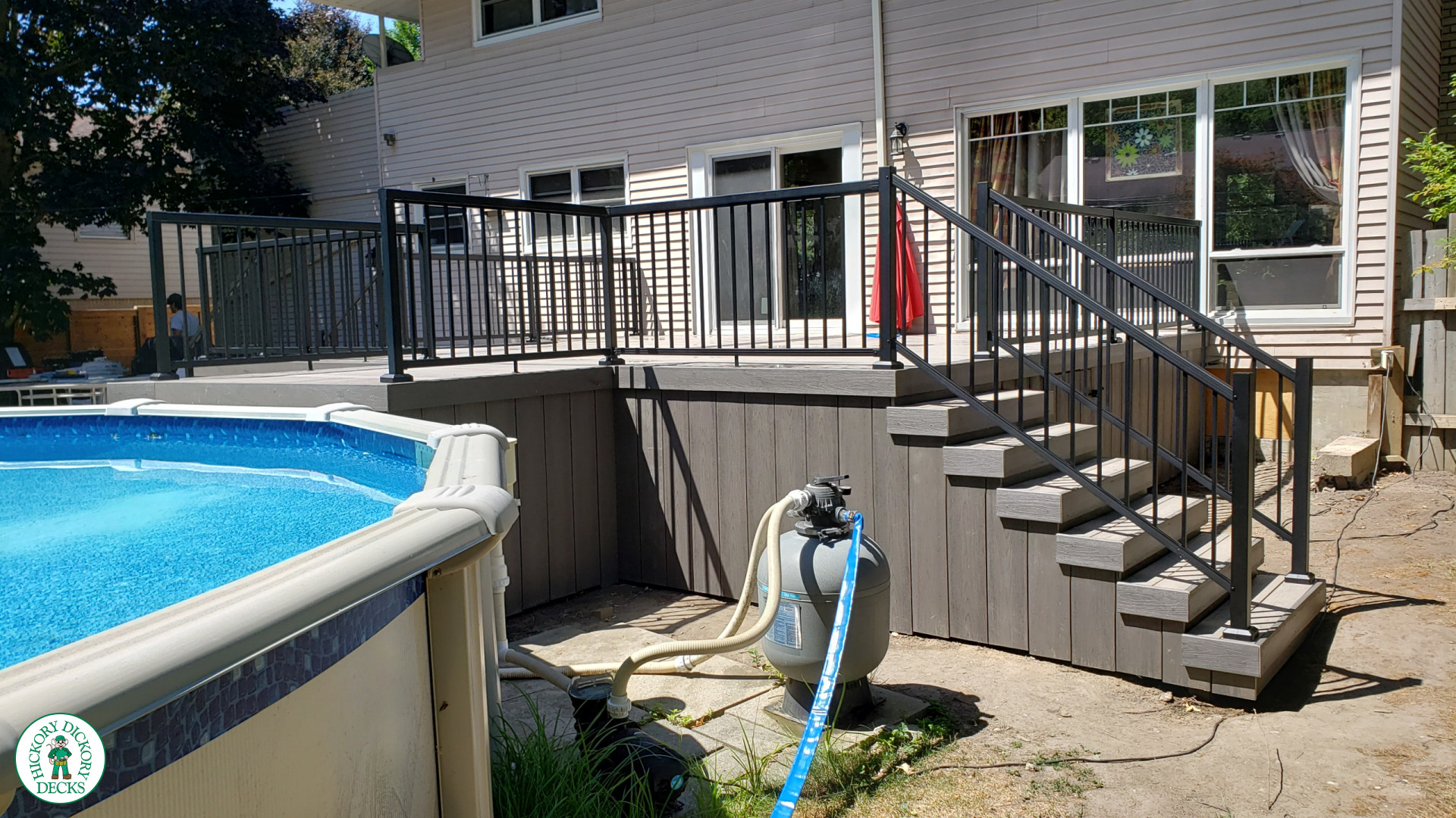 Grey above ground pool deck with black aluminum railings
