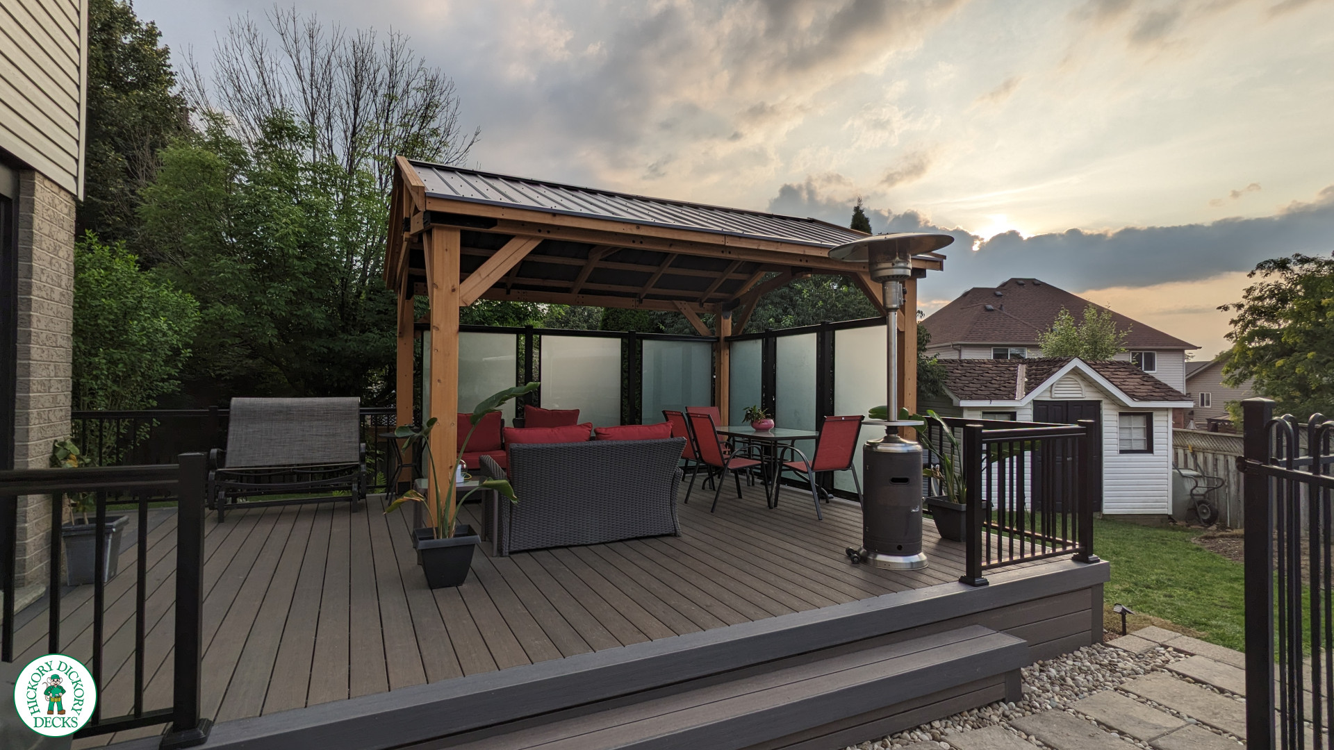Mid size dark brown deck with dark grey border, a custom roof structure, and frosted glass privacy screens.