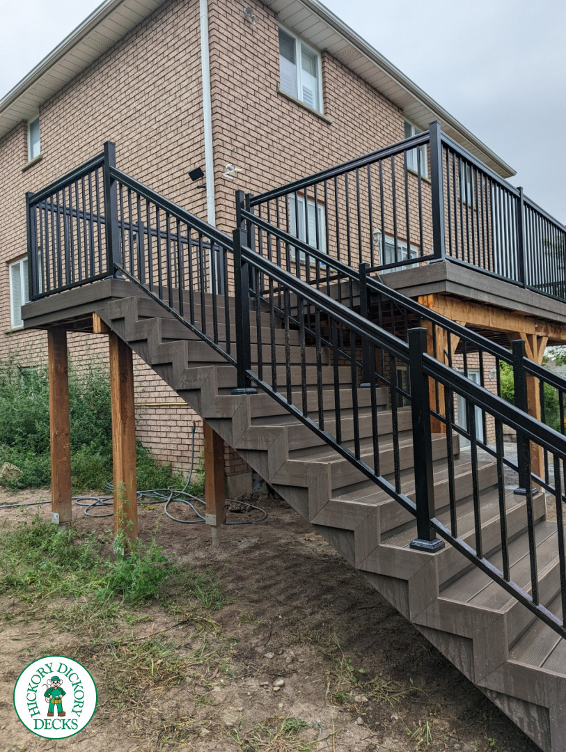 High clubhouse deck with stairs leading up to top, and black aluminum railing.