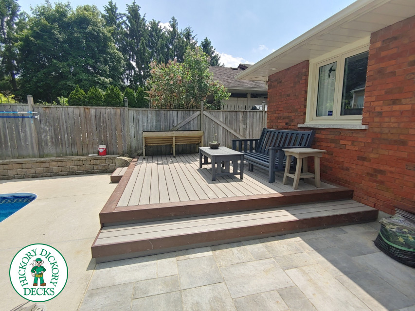 Small low trunorth grey deck with brown border and steps.