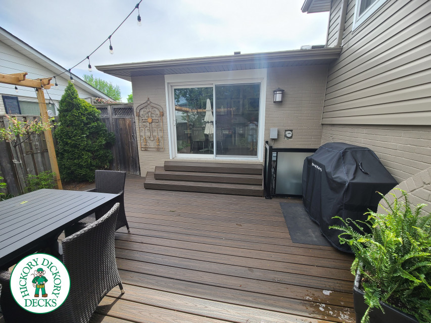 Large brown composite deck with pergola and unique stairs.