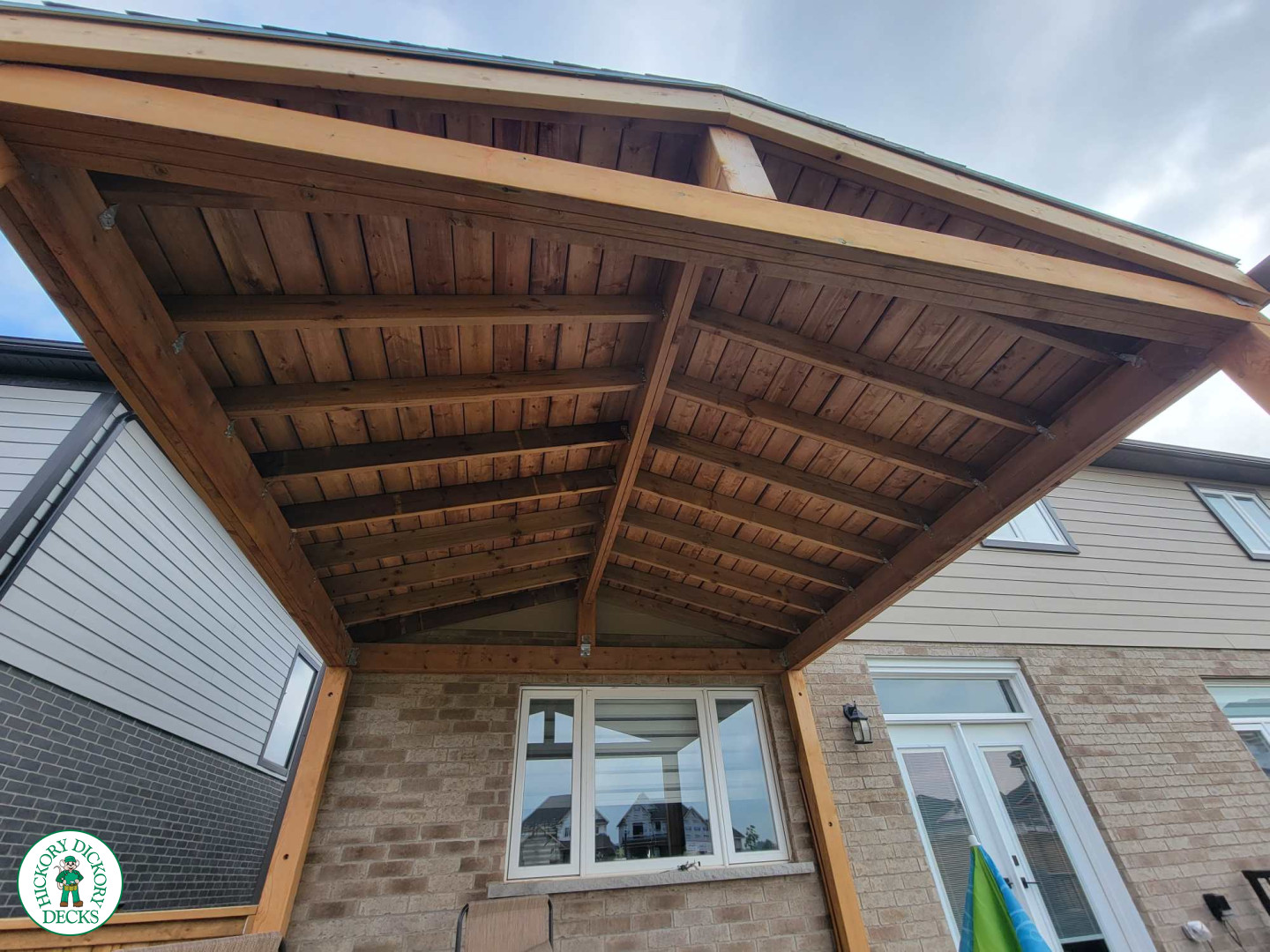 Large grey clubhouse deck with black aluminum railing and a custom cedar roof structure