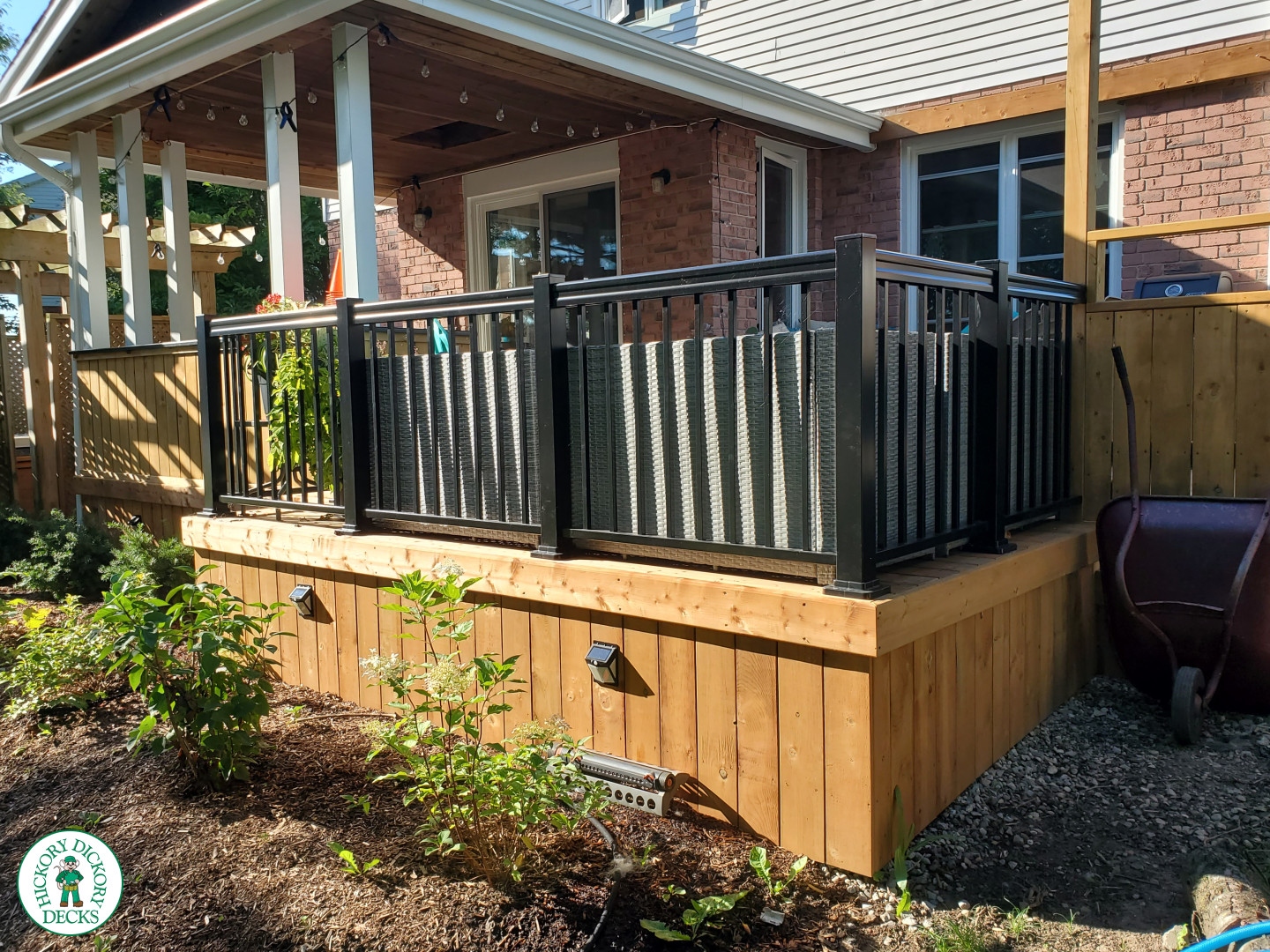 Cedar deck with roof structure that has a built in bar, and aluminum railings with a gate insert.