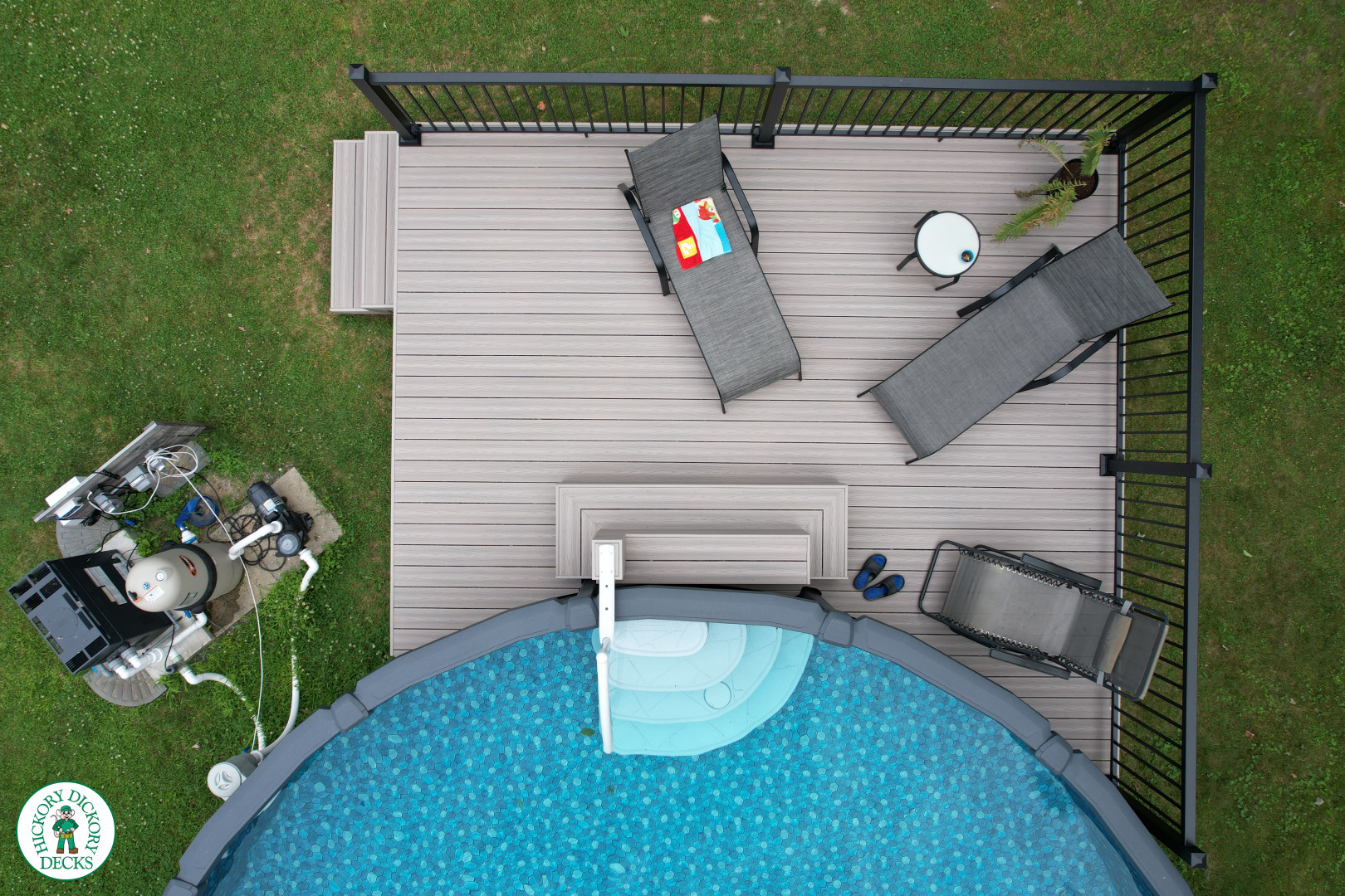 Small grey fiberon deck built around an above ground pool.