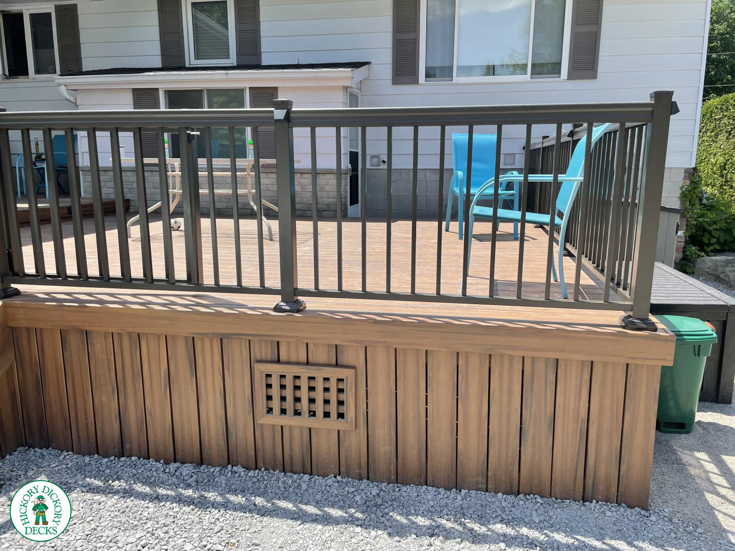 Small brown composite deck with steps and black aluminum railing.
