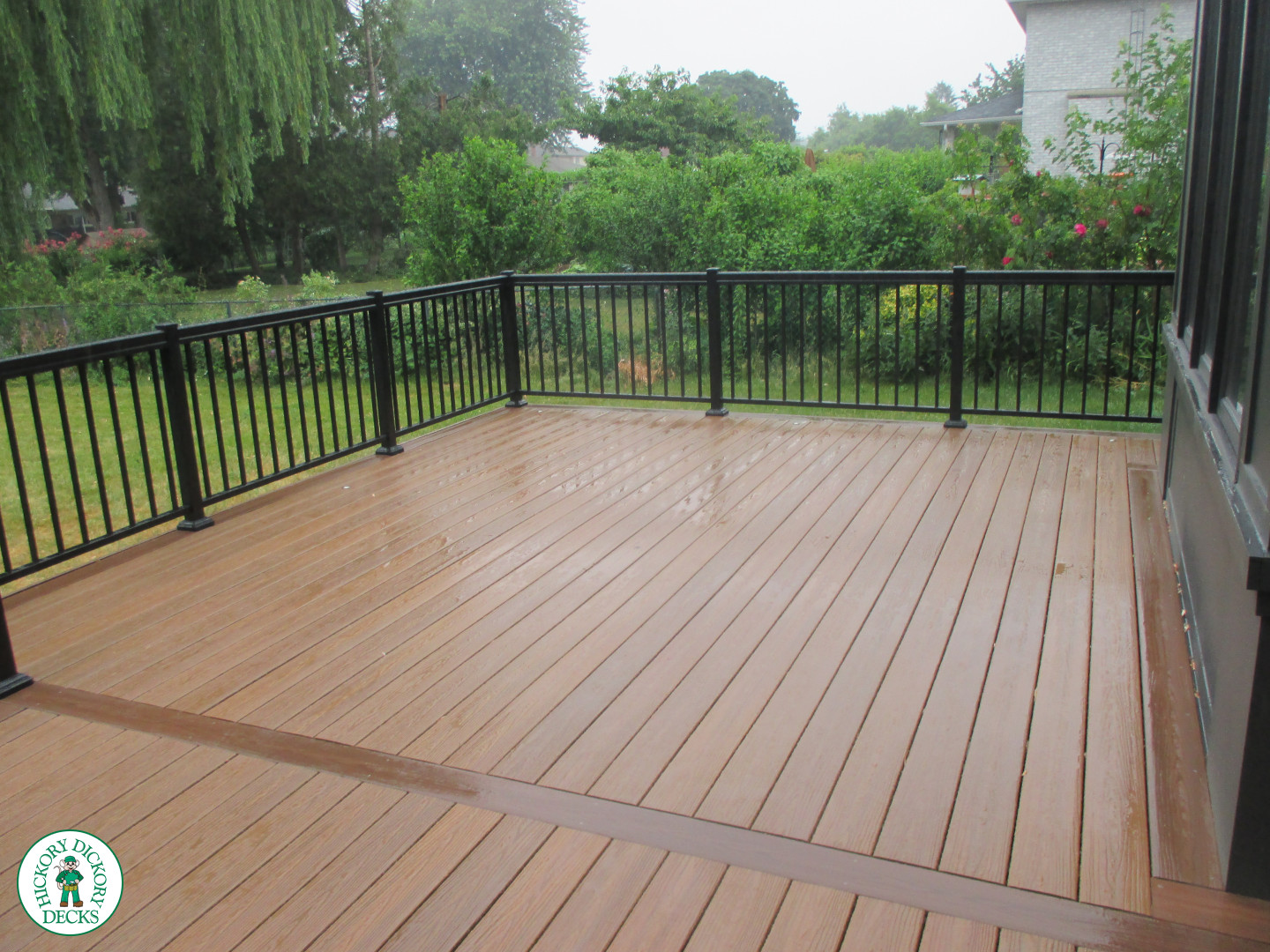Low brown composite deck with black aluminum railing