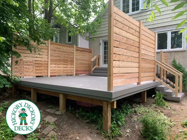 Grey fiberon deck with cedar railing and a cedar privacy screen.