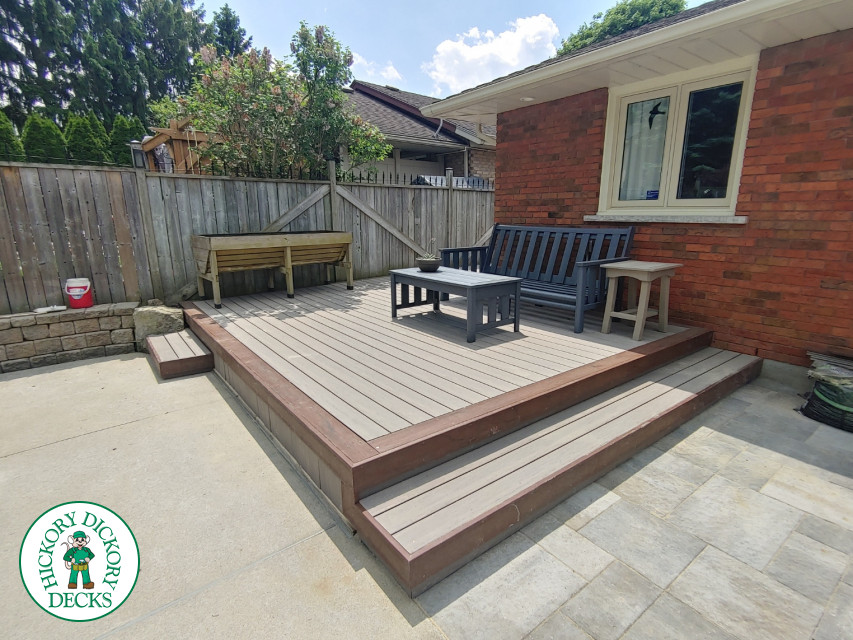 Small low trunorth grey deck with brown border and steps.